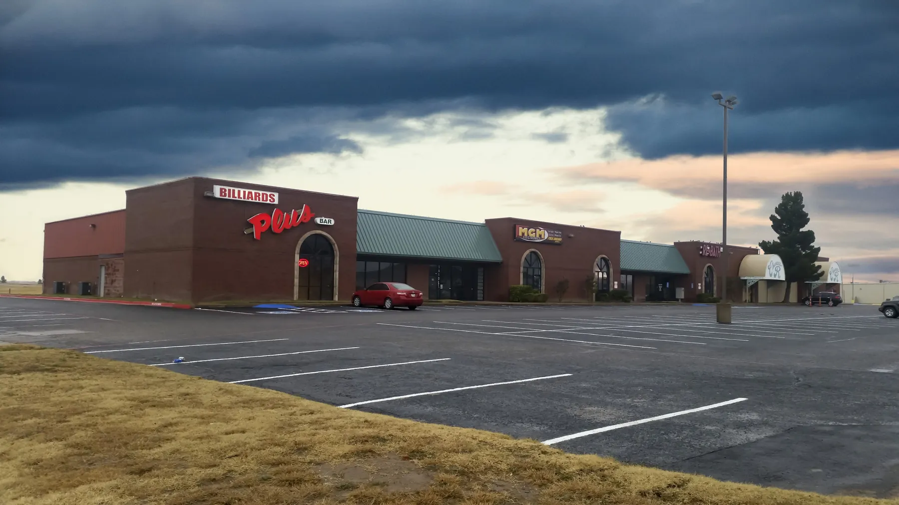 Frankford Center's brick storefronts and Billiards Plus sign under a stormy sky, photographed in 2016