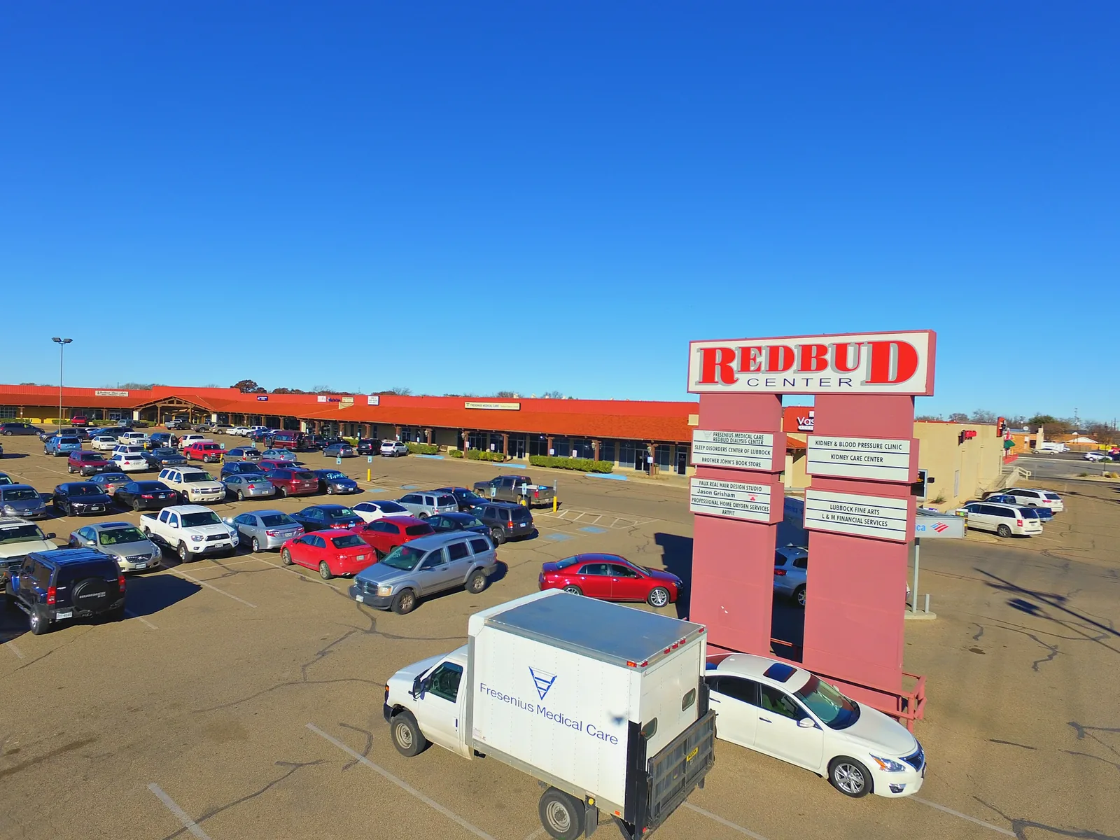 The Redbud Center pylon sign and storefronts along Slide Road, photographed from a drone in 2015